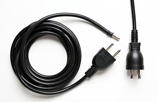 Black coiled electric power extension cable with plugs. Isolated on white background. Ready for connecting devices. Power supply cord used for electricity.