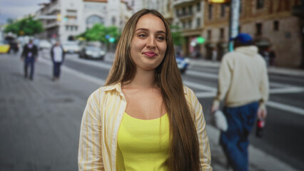 Obraz premium Woman smiling on city street crosswalk near taxi, wearing yellow tank top and open shirt; joy confidence wellbeing.