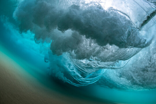 Powerful underwater wave breaking over sandy seabed at Bondi Beach, Sydney, Australia, showing turbulent water, air bubbles, and motion beneath the ocean surface.