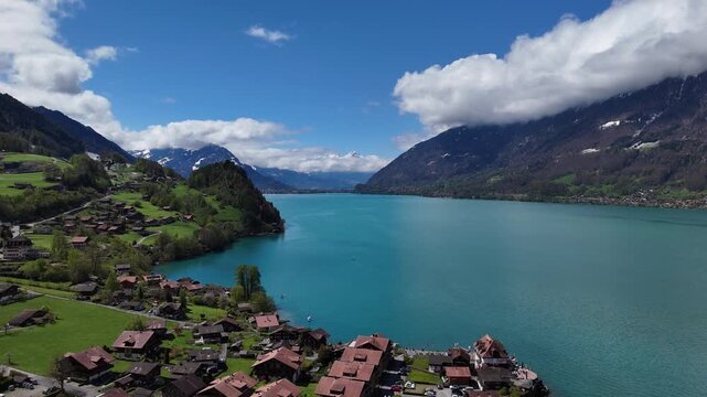 Cinematic Aerial Reveal of the Swiss mountain village of Iseltwald by crystal clear lake