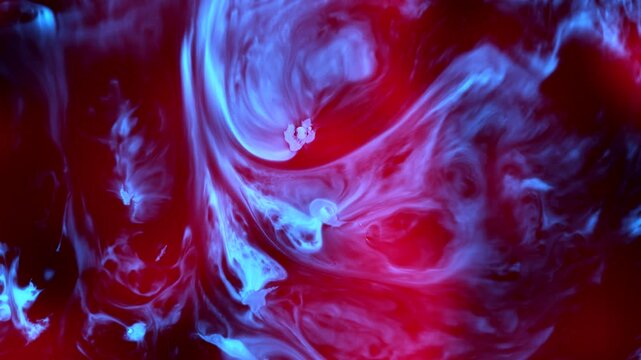 Real organic red and blue ink mixing in water. Abstract macro liquid background with vibrant swirling cells resembling cosmic nebula or sci-fi plasma energy for cinematic VFX motion graphics 4K.