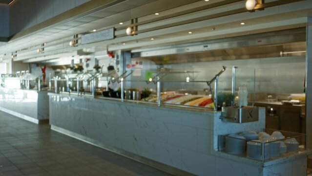 Blurred buffet counter and serving line with soft bokeh focus in an interior; background backplate copyspace calm.