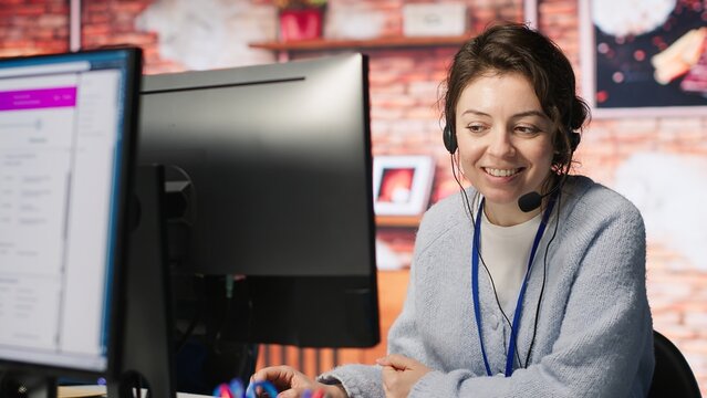 Teamworking cheerful call center agents tracking shipments in office. Upbeat customer center colleagues use software to locate clients packages and provide status updates, camera A close up