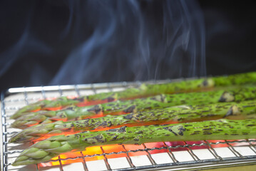 煙り立ち昇る七輪でアスパラガスを焼く