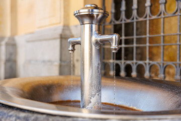 Close-up of stainless steel outdoor water fountain with gentle flowing streams