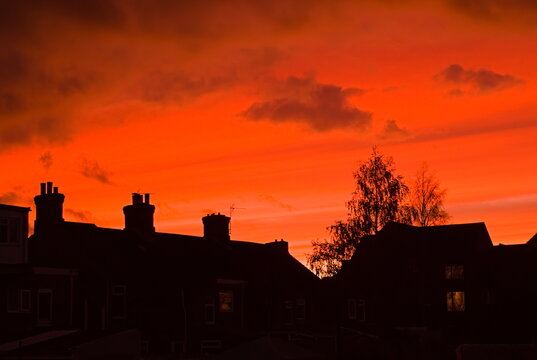 stunning sunset over house rooftops in Silhouette