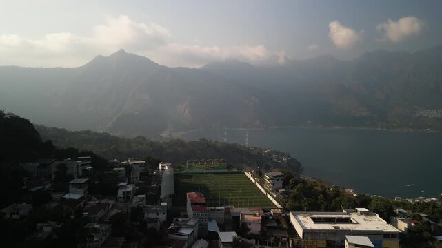 Aerial ascending above soccer stadium and Nariz del Indio at San Pedro La Laguna Lake Atitlan Guatemala