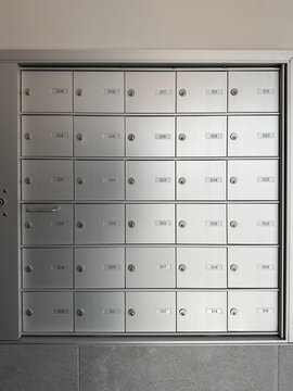 Bo&icirc;tes aux lettres m&eacute;talliques align&eacute;es dans un bureau moderne. Gros plan