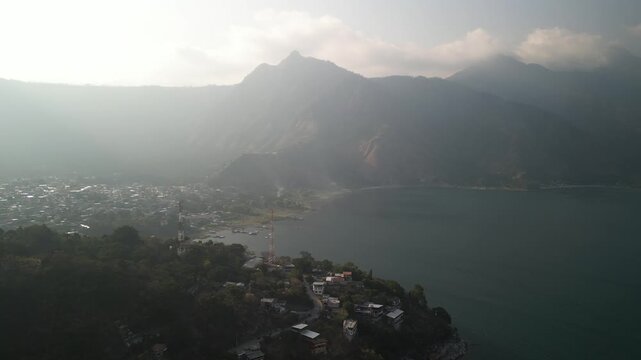 Aerial of Nariz del Indio above San Juan La Laguna town on Lake Atitlan in Guatemala at sunset