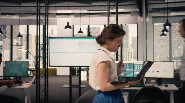 Agitated woman pacing the floor in modern office and being impatient, fidgeting and walking back and forth due to nervousness. Focused and anxious female worker, business intelligence.