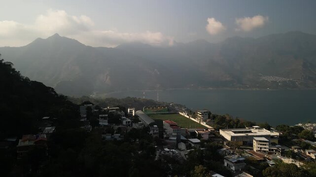 Aerial of soccer stadium and Nariz del Indio above San Pedro La Laguna on Lake Atitl&aacute;n