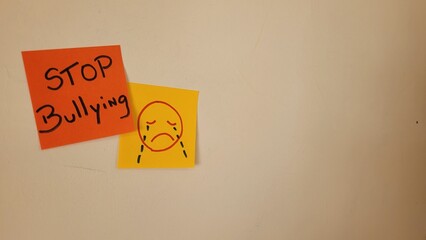 Stop Bullying message on sticky notes with sad face drawing
