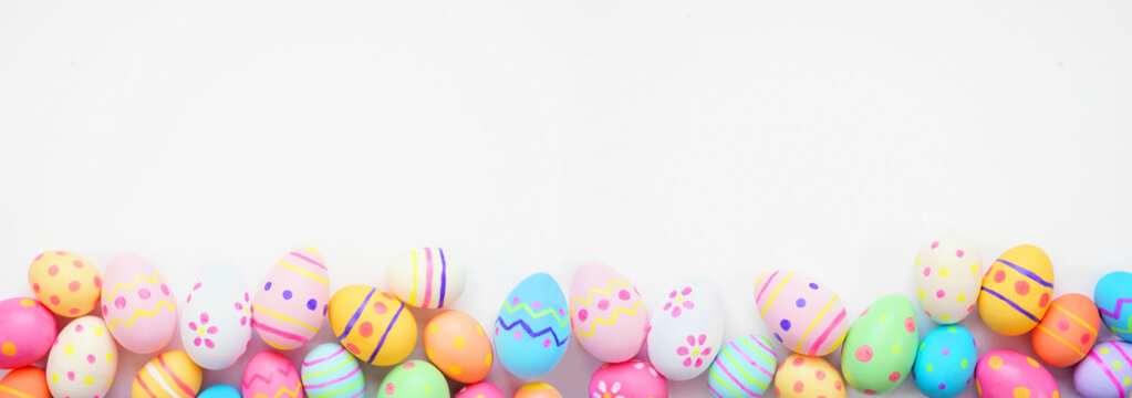Colorful Easter Egg bottom border against a white banner background. Top view with copy space.