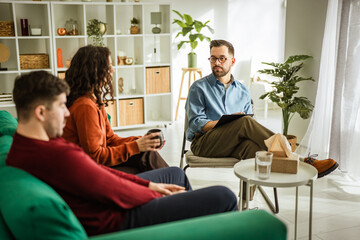Couple discussing relationship problems with a male psychotherapist