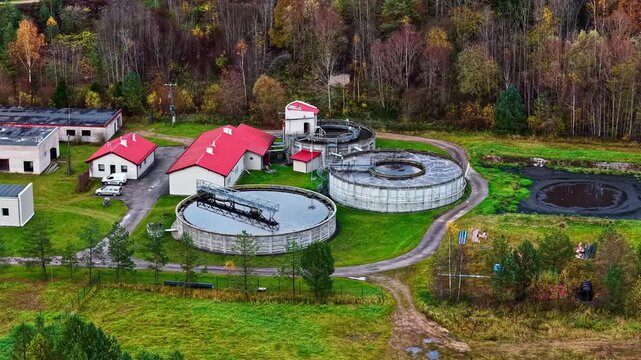 Drone panorama of a rural wastewater plant surrounded by colorful fall trees