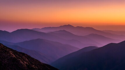 Stunning Layers of Mountain Ranges at Sunset with Vibrant Orange and Purple Hues.