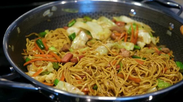 Pancit preparation in a kitchen in the Philippines with fresh vegetables and noodles.