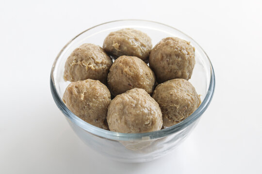 A minimalist and clean presentation of Smooth Beef Meatballs (Bakso Sapi Halus) in a glass bowl.