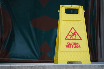 Caution sign stands in front of wet floor area