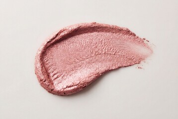 Fototapeta premium Shimmering pink metallic cosmetic product swatch with textured surface on light background