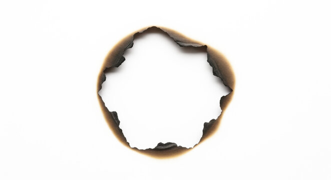 Burnt hole in white paper with charred edges isolated on transparent background