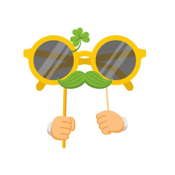A playful illustration of hands holding props with sunglasses, a mustache, and a shamrock on a white background for St. Patrick's Day.