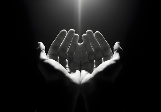 Black and White Image of Hands Cupped Together Receiving a Single Light Beam cupped hands open hands