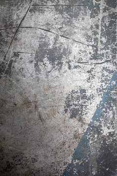 Close-up texture of a heavily scratched and worn metal surface with a blue stripe