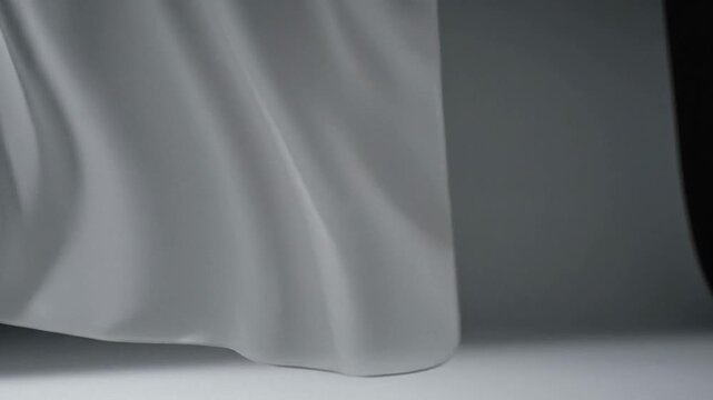 Soft white fabric drape on dark studio background, minimalist textile texture for fashion mockups and luxury branding, calm elegant mood suited for winter holiday campaigns