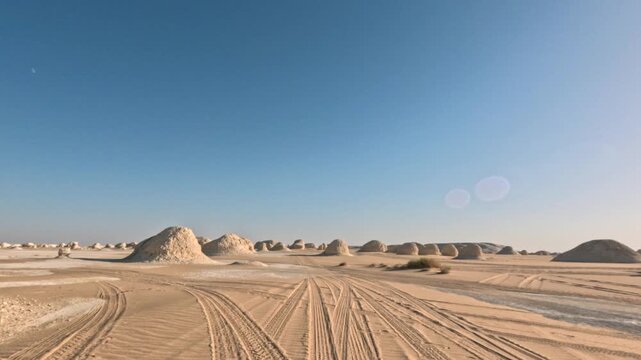 Fast pov driving on the road in white desert with sand and rocks around. Cinematic fpv motion shot 