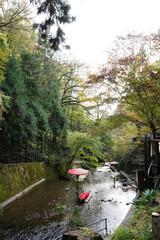 京都貴船川の流れの中に設置された紅い和傘と緋毛氈が掛けられた縁台