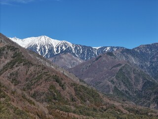 Obraz premium The mountains are covered in snow and the sky is clear. The mountains are very tall and the snow is very white