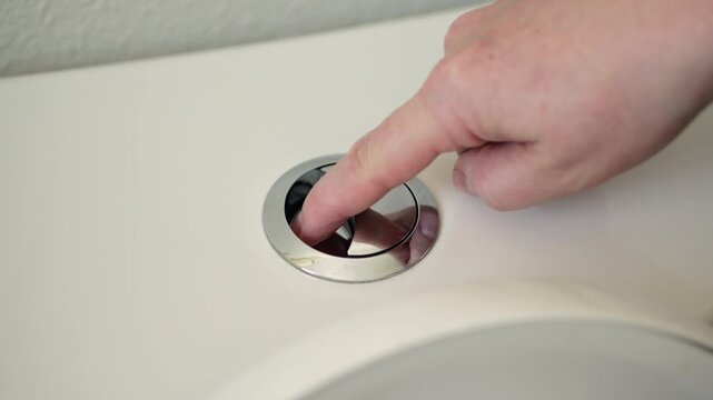 Hand pressing toilet flush dual button