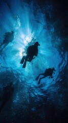 Divers Swimming Towards Sunlit Water Surface