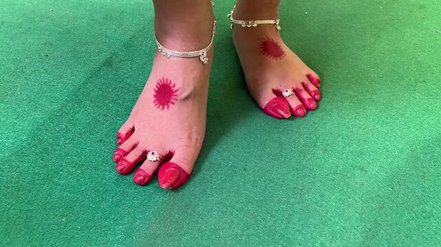 Indian bride showing her anklet and alta legs