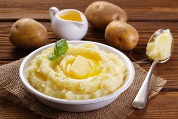 Creamy mashed potatoes served with butter and fresh herbs on a rustic table setting