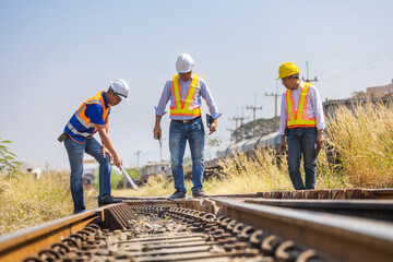 Railway engineers inspecting track condition during safety assessment, Transportation worker checking rail infrastructure at site, Railway engineer walking along track during infrastructure inspection