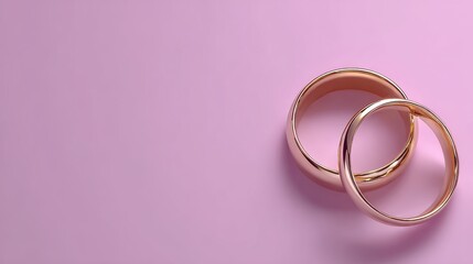 Elegant Wedding or Engagement banner background - pair of golden wedding rings and gentle white bow ribbon on gentle pink backdrop, copy space for text