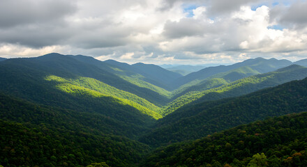 Fototapeta premium A serene mountain landscape with lush green hills under a cloudy sky