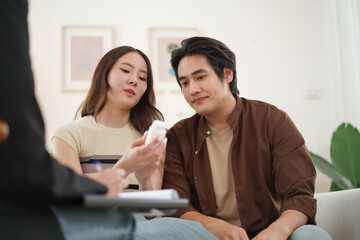 Asian couple reading medicine label during mental health treatment session
