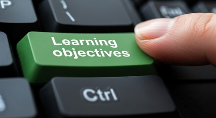 Finger Pressing Green Learning Objectives Button on Computer Keyboard