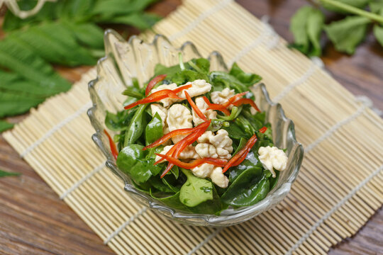 Cold dish of peach kernels and andrographis paniculata served in a dish