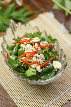 Cold dish of peach kernels and andrographis paniculata served in a dish