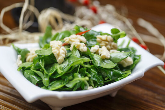 Cold dish of peach kernels and andrographis paniculata served in a dish
