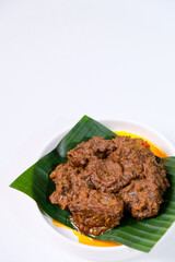 Rendang is traditional food from West Sumatra, Indonesia. It is made from beef stew and coconut milk with various herbs and spice. Isolated on white background