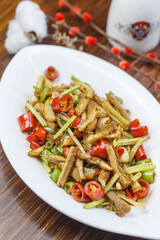 Hunan-style stir-fried eel segments served on a leaf-shaped porcelain plate