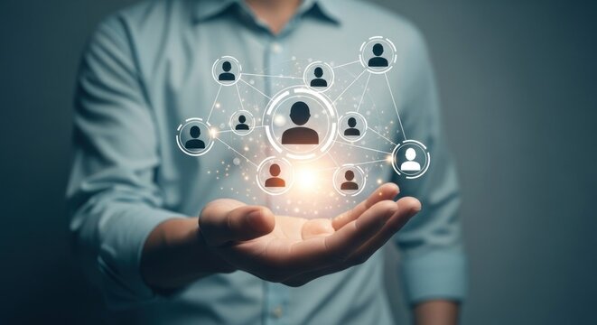 Person holds illuminated network of connected human icons in hand