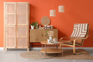 Interior of stylish living room with armchair, table and folding screen