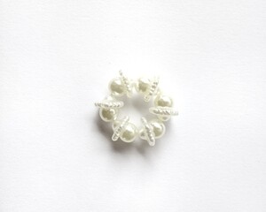 Elegant handmade pearl beaded ring isolated on white background.