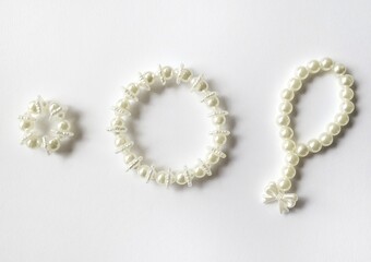 Set of handmade pearl beaded accessories isolated on white background.